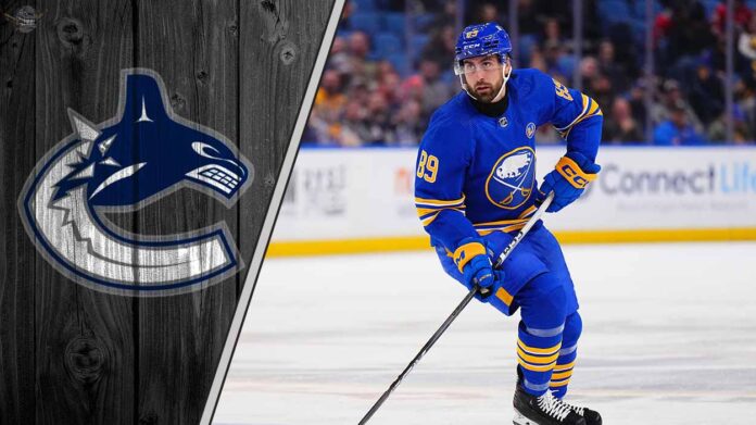 Buffalo Sabres forward Alex Tuch skates with the puck, with the Vancouver Canucks logo in the background, representing the latest NHL trade rumors.
