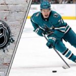 NHL future star Macklin Celebrini in his San Jose Sharks jersey skating with the puck