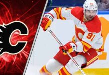 Calgary Flames center Nazem Kadri skates during an NHL game, looking focused despite recent NHL trade rumors surrounding him and the team.