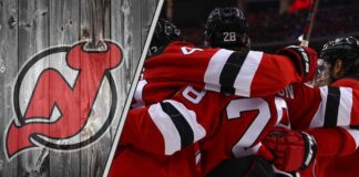 An action shot of the New Jersey Devils team celebrating a goal, illustrating their ambition for a deep playoff run and potential trade reinforcements.