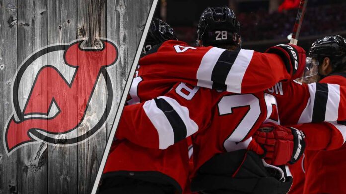 new-jersey-devils-playoff-ambition-trade-targets An action shot of the New Jersey Devils team celebrating a goal, illustrating their ambition for a deep playoff run and potential trade reinforcements.