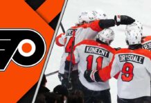 The Philadelphia Flyers team celebrating a goal on the ice, showcasing their teamwork and determination.