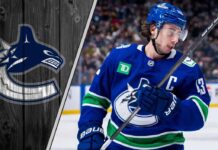 Vancouver Canucks captain Quinn Hughes on the ice, skating with his stick.