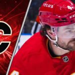 Calgary Flames defenseman Rasmus Andersson skates with the puck during an NHL game.