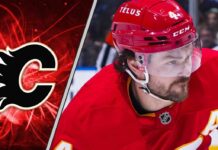 Calgary Flames defenseman Rasmus Andersson skates with the puck during an NHL game.