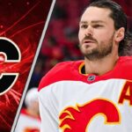 Calgary Flames defenseman Rasmus Andersson skates with the puck, with the Vegas Golden Knights logo in the background, symbolizing a potential trade.