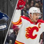 Calgary Flames forward Mikael Backlund celebrating a goal with the Vancouver Canucks logo to the right signifying NHL trade rumors