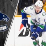 The Inevitable Question: Can the Vancouver Canucks Afford to Keep Quinn Hughes? Vancouver Canucks captain Quinn Hughes skates with the puck during a game, contemplating his future with the team amidst NHL trade rumors.