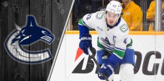 Vancouver Canucks captain Quinn Hughes skates with the puck during a game, contemplating his future with the team amidst NHL trade rumors.