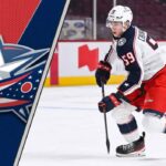 Yegor Chinakhov skates in his Columbus Blue Jackets uniform, looking for a pass as NHL trade rumors link him to the Toronto Maple Leafs and Detroit Red Wings.