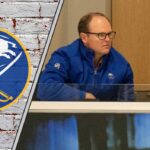 Buffalo Sabres GM Kevyn Adams looks on from the press box, contemplating his next move as trade rumors swirl around the team.