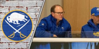 Buffalo Sabres GM Kevyn Adams looks on from the press box, contemplating his next move as trade rumors swirl around the team.