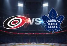 Can the Leafs Stop the Storm? Hurricanes vs. Maple Leafs TV, Prediction, and Odds A stylized image showing the Carolina Hurricanes logo and the Toronto Maple Leafs logo colliding, with "Vs" between them. The background is an illuminated hockey arena interior with Coca-Cola logos on the boards.