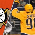 Nashville Predators center Ryan O'Reilly celebrates a goal during a game, with the logo for the Anaheim Ducks symbolizing a potential trade.