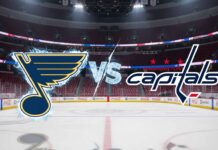 A stylized, widescreen matchup graphic showing the St. Louis Blues logo, covered in frost, and the Washington Capitals logo, engulfed in flames, colliding over center ice. An icy 'VS' text separates them. The background features a wide view of the Capitals' home arena, with spotlights shining on the logos and Coca-Cola decals visible on the boards.