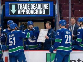 Vancouver Canucks Reportedly “Open for Business” on Veteran Stars Vancouver Canucks players on the ice discussing strategy, representing the team entering trade deadline sell mode.