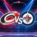 Stylized graphic showing the Carolina Hurricanes logo and Winnipeg Jets logo colliding with a "VS" between them, spotlighted over center ice inside a packed Canada Life Centre arena.