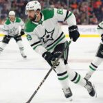 A photo of Dallas Stars player Alex Tuch, wearing number 89, skating with the puck during a game. Two other Stars players are in the background.