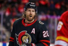 A close-up photograph captures Ottawa Senators forward Blake Coleman wearing his black home jersey, complete with the alternate captain's "A" and number 20, looking towards the camera with an open-mouthed expression during a game against the Calgary Flames.