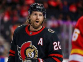 A close-up photograph captures Ottawa Senators forward Blake Coleman wearing his black home jersey, complete with the alternate captain's "A" and number 20, looking towards the camera with an open-mouthed expression during a game against the Calgary Flames.