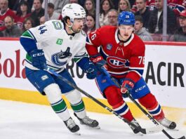 Vancouver Canucks winger Kiefer Sherwood skating against Montreal Canadiens forward Zach Bolduc during an NHL game.