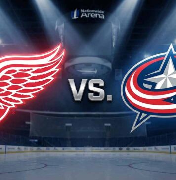 A wide-angle view of the glowing, stylized logos for the Detroit Red Wings and Columbus Blue Jackets facing off with the word "VS." between them. They are spotlights over the ice at Nationwide Arena.