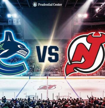Canucks vs Devils TV Channel, Live Stream & Odds (Dec 14, 2025) A wide-angle view inside the Prudential Center arena, featuring the Vancouver Canucks and New Jersey Devils logos floating above the center-ice circle, separated by a large "VS" graphic. Spotlights illuminate the logos and the ice surface, which also shows the Devils' center-ice logo.