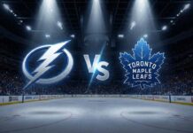 How to Watch Tampa Bay Lightning at Toronto Maple Leafs: TV, Time & Prediction A stylized widescreen graphic showing the Tampa Bay Lightning logo and Toronto Maple Leafs logo colliding with a large "VS" between them at center ice of a dark hockey arena. Spotlights shine down on the logos, and Coca-Cola advertisements are visible on the rink boards in the background.