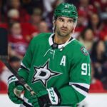 Report: Dallas Stars Zeroing in on Nazem Kadri Following Seguin Injury Nazem Kadri, wearing a Dallas Stars number 91 jersey with an 'A' patch and helmet, stands on the ice holding his stick and looking to the side during a game.