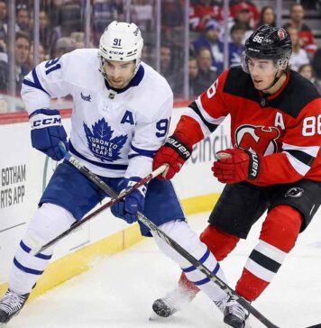 How to Watch New Jersey Devils at Toronto Maple Leafs: TV & Streaming Guide Toronto Maple Leafs' John Tavares (91) and New Jersey Devils' Jack Hughes (86) battle fiercely for possession of the puck along the boards during an NHL game.