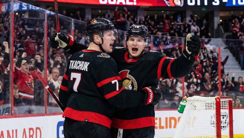 Ottawa Senators captain Brady Tkachuk and a teammate celebrate a goal during a game, with a news banner below highlighting the latest Ottawa Senators trade rumors and news ahead of the deadline.
