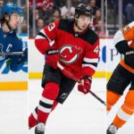 Triptych image showing NHL defenseman Quinn Hughes in three different uniforms side-by-side: his current blue Vancouver Canucks jersey on the left, a red New Jersey Devils jersey in the center, and an orange Philadelphia Flyers jersey on the right, illustrating the latest NHL trade rumors.