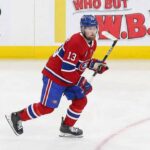 Is Alexis Lafrenière a Fit for Montreal? The Hard Truth Behind the Rumors Alexis Lafrenière skating on the ice wearing a red Montreal Canadiens home uniform with the number 13 and a blue helmet.
