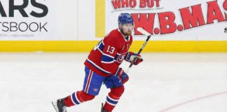 Alexis Lafrenière skating on the ice wearing a red Montreal Canadiens home uniform with the number 13 and a blue helmet.