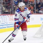Artemi Panarin of the New York Rangers skating in his home jersey while a female fan in the stands wearing a Rangers jersey holds a sign reading "Thanks for the memories Artemi!" amidst trade rumors.