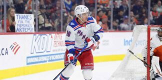 Artemi Panarin of the New York Rangers skating in his home jersey while a female fan in the stands wearing a Rangers jersey holds a sign reading "Thanks for the memories Artemi!" amidst trade rumors.