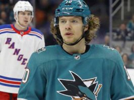 Will the Sharks Land Panarin? The Blockbuster Trade Rumor Heating Up A composite image showing Artemi Panarin in a teal San Jose Sharks uniform and helmet amidst trade speculation, with players wearing white New York Rangers away jerseys visible in the background.