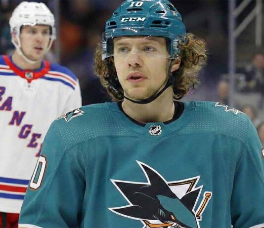 Will the Sharks Land Panarin? The Blockbuster Trade Rumor Heating Up A composite image showing Artemi Panarin in a teal San Jose Sharks uniform and helmet amidst trade speculation, with players wearing white New York Rangers away jerseys visible in the background.