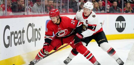 How to Watch Hurricanes at Senators: TV Schedule, Odds & Prediction Carolina Hurricanes forward Sebastian Aho (#20) in a red jersey battling with Ottawa Senators captain Brady Tkachuk (#7) in a white jersey for puck possession along the rink boards during an NHL game.