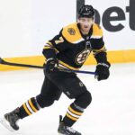 Boston Bruins defenseman Dougie Hamilton, wearing the number 7 black home jersey, skates across the ice holding his stick and looking forward with a focused expression during a game.