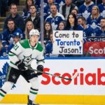 Leafs Trade Rumors: The $12M Winger That Could Cost Easton Cowan Jason Robertson of the Dallas Stars in his white away uniform skates on the ice during an NHL game against the Toronto Maple Leafs, with fans visible in the stands behind the glass.