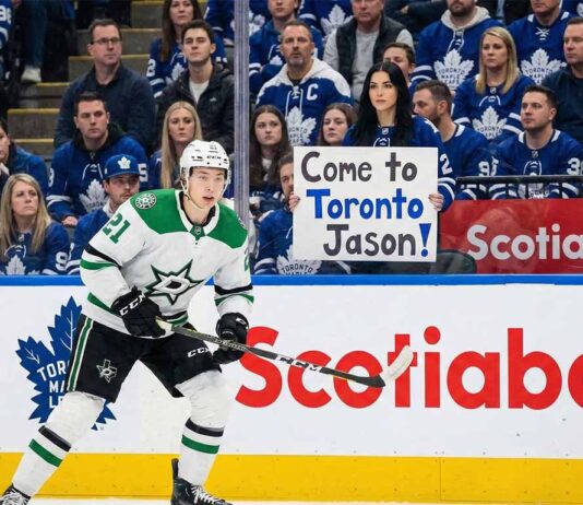Leafs Trade Rumors: The $12M Winger That Could Cost Easton Cowan Jason Robertson of the Dallas Stars in his white away uniform skates on the ice during an NHL game against the Toronto Maple Leafs, with fans visible in the stands behind the glass.