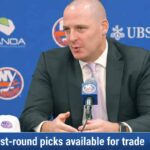 Going All-In: Why the New York Islanders Are Open to Trading a 2026 First-Round Pick New York Islanders GM Mathieu Darche speaking at a press conference with a news graphic banner overlay at the bottom reading "2026 first-round picks available for trade."