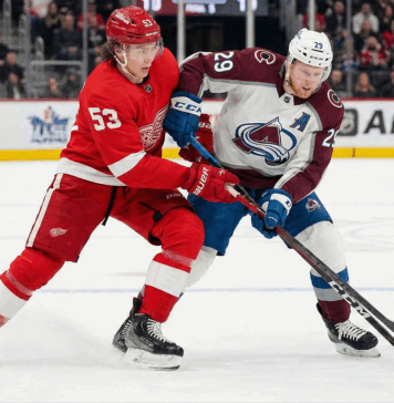 Avalanche vs Red Wings TV Schedule: Why You Can’t Miss This Saturday Matinee Clash Detroit Red Wings defenseman Moritz Seider (53) in a red home jersey and Colorado Avalanche forward Nathan MacKinnon (29) in a white and maroon away jersey battle fiercely for the puck along the boards during an NHL game at Little Caesars Arena.