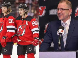 Devils Crisis: Inside the Search for a Savior After Humiliating Defeat A split-screen photograph. On the left side, two New Jersey Devils hockey players, wearing red number 91 and number 86 jerseys, smile while standing on the ice holding their sticks. On the right side, New Jersey Devils General Manager Tom Fitzgerald, wearing a navy suit and glasses, speaks into a microphone at a podium inside the Prudential Center, with Devils and MSG logos in the background.
