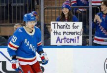 New York Rangers player Artemi Panarin #10 skates on the ice while a smiling female fan behind the glass holds a handwritten sign that reads, "Thanks for the memories Artemi!".