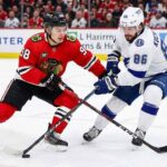 Why You Can’t Miss Bedard vs. Kucherov: Lightning at Blackhawks TV & Streaming Guide Chicago Blackhawks center Connor Bedard (98) in a red home jersey and Tampa Bay Lightning winger Nikita Kucherov (86) in a white away jersey battle fiercely for puck possession with their sticks crossed during an NHL game at the United Center.