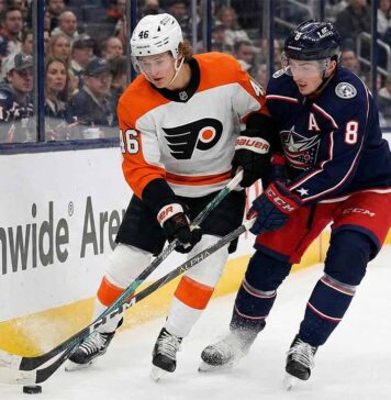 Can the Rested Blue Jackets Bury the Flyers in Tonight’s Metro Clash? Philadelphia Flyers forward Trevor Zegras (#46) in a white away jersey and Columbus Blue Jackets defenseman Zach Werenski (#8) in a navy home jersey battle for a loose puck against the boards during an NHL game at Nationwide Arena.