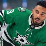 NHL player Evander Kane wearing a green victory Dallas Stars home jersey with the number 9, holding his stick on the ice and looking towards the right side of the frame.