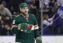 NHL center Vincent Trocheck depicted wearing a green Minnesota Wild home uniform, helmet, and gloves while on the ice during a game situation.
